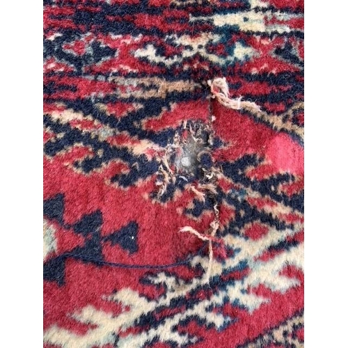 11 - Machine woven carpet of Turkoman design with six rows of gols on wine ground with borders, 11ft 4ins... 