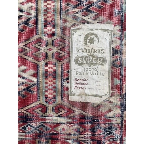 11 - Machine woven carpet of Turkoman design with six rows of gols on wine ground with borders, 11ft 4ins... 