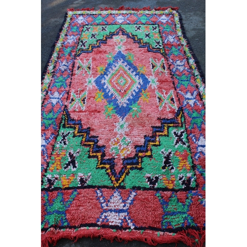19 - Berber rug of polychrome medallion design with rose ground, 11ft 6ins x 5ft 4ins approximately