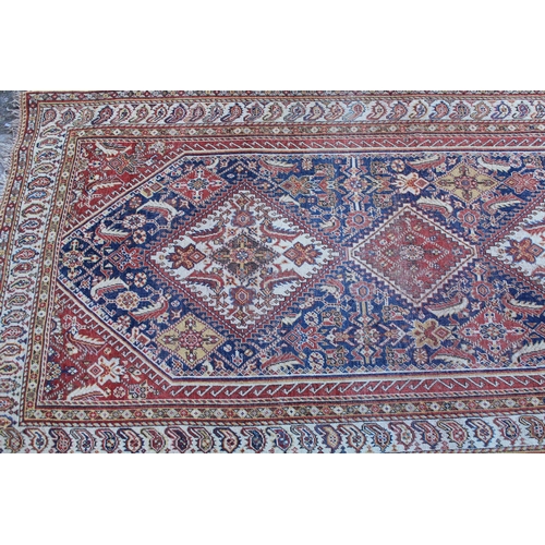 28 - Small Qashqai rug with a triple repeating medallion design on a midnight blue ground with corner des... 