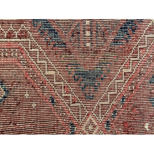 32 - Large good quality machine woven carpet of Turkoman design with multiple rows of gols on a wine red ... 
