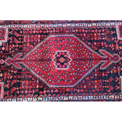 36 - Large Hamadan rug with lobed medallion and all-over design with corner designs in shades of red and ... 