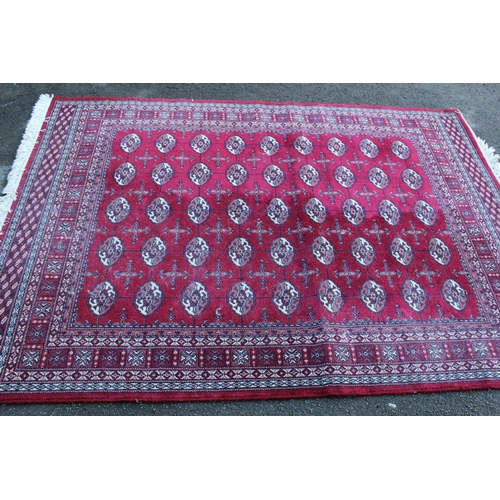 4 - Machine woven rug of Turkoman design with five rows of nine gols on a red ground, 8ft x 5ft 8ins app... 