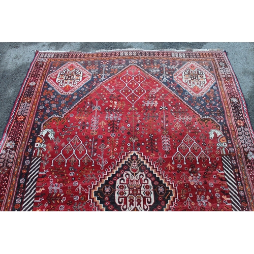 40 - Qashqai rug with central medallion design on red and blue ground with borders, 96ins x 64ins