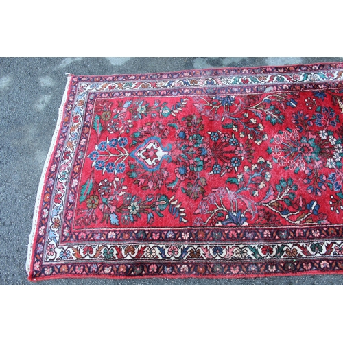 8 - Sarouk runner with a typical all-over floral design on a red ground with border, 17ft 8ins x 3ft 6in... 
