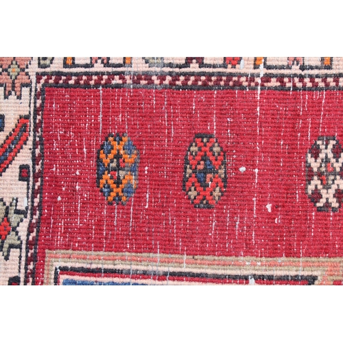 13 - Kurdish rug with a quadruple pole medallion design in shades of red and blue with a triple border, 9... 