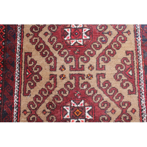 14 - Afghan runner with a multiple hooked medallion design on a beige ground with borders, 11ft 3ins x 3f... 