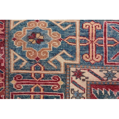 5 - Modern Afghan rug of Caucasian design with a rams horn and all-over stylised design on a rust ground... 