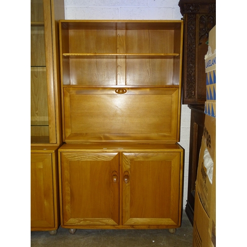 40 - A modern Ercol light elm cabinet/shelves unit, the upper section fitted with a shelf above, on hinge... 