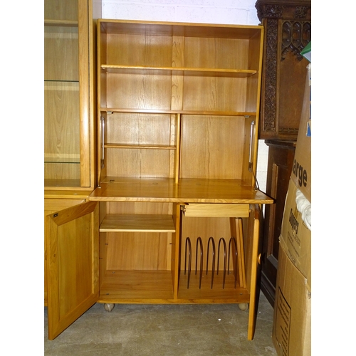 40 - A modern Ercol light elm cabinet/shelves unit, the upper section fitted with a shelf above, on hinge... 