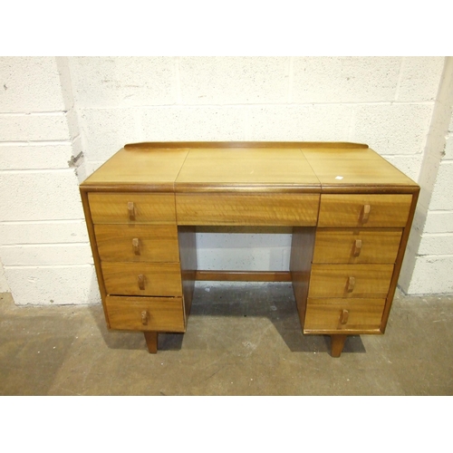 9 - A mid-20th century knee-hole dressing table with folding mirror and eight drawers, 107cm wide, a lim... 