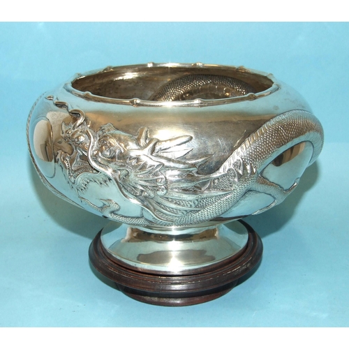 A Chinese silver rose bowl of squat form, with raised decoration of a dragon, character marks and Yok Sang to base rim, 20cm diameter, 13cm high, ___19oz.