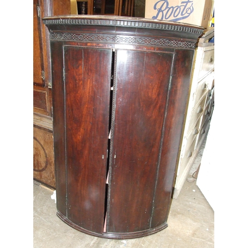 20 - A George III mahogany bow-fronted hanging corner cupboard with dentil cornice, 74cm wide, 114cm high... 