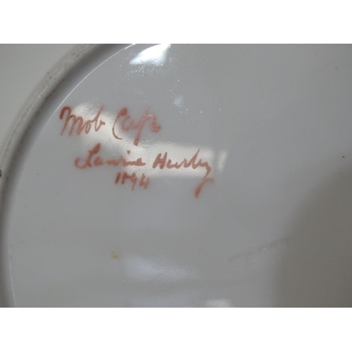 77 - A pair of Derby ceramic plates, each painted with a portrait of a young woman wearing a mob cap, 23.... 