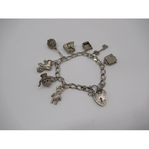 11 - Sterling silver charm bracelet including charms of Holy Bible, warming pan, boot, teddy etc with hea... 