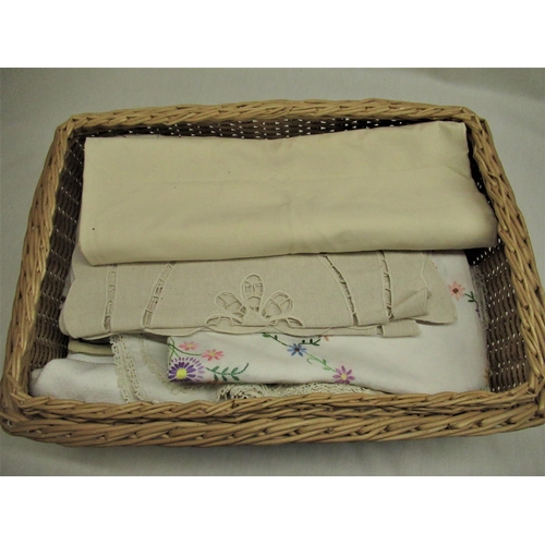 567 - Wicker basket containing a selection of embroidered and lace edged table linen