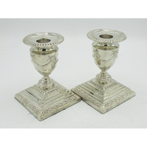 1195 - Pair of Geo.V hallmarked sterling silver candlesticks, urn shaped sconces relief decorated with bows... 