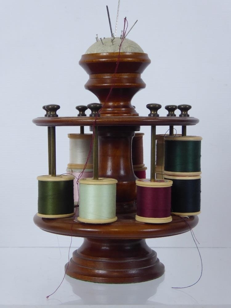 A Wood Turned Cotton Reel Holder, with fitted pin cushion finial, holds ...