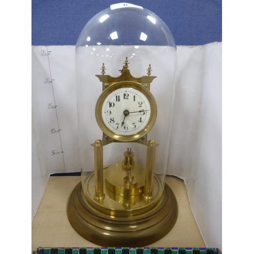 6 - Brass anniversary-style mantel clock under a glass dome.