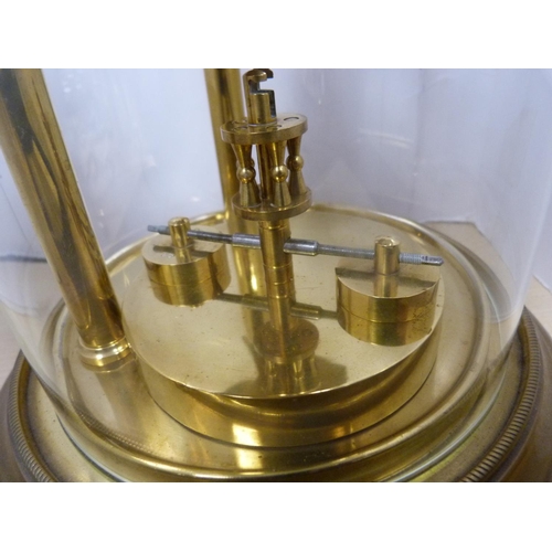 6 - Brass anniversary-style mantel clock under a glass dome.