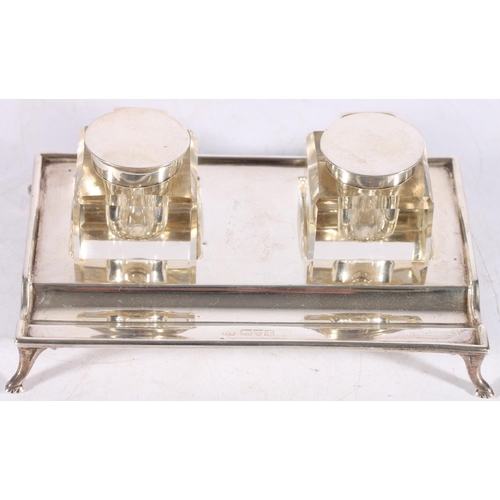 33 - George V sterling silver desk stand of rectangular form on paw supports with two glass and silver mo... 