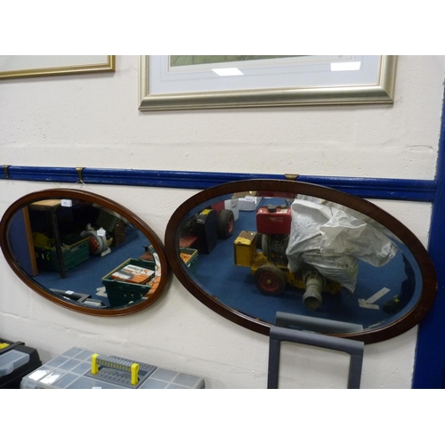 11 - Two mahogany and stained wood oval wall mirrors.  (2)
