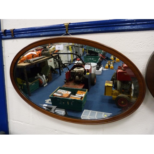 11 - Two mahogany and stained wood oval wall mirrors.  (2)