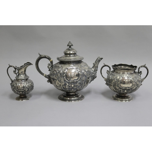 Antique mid Victorian sterling silver three piece tea service, comprising a tea pot, open sugar, and creamer, marked for London 1871 by Martin Hall & Co. Total weight approx 1.9 kg (3)