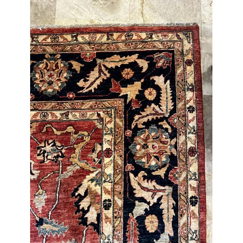 1058 - Large Persian hand knotted wool carpet, of central red ground and deep blue boarder, approx 5.3 Metr... 