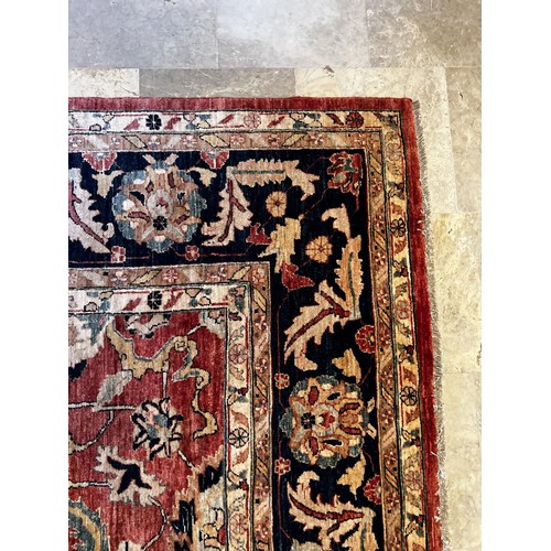 1058 - Large Persian hand knotted wool carpet, of central red ground and deep blue boarder, approx 5.3 Metr... 