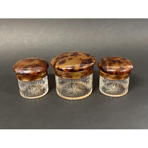 1018 - Set of three clear etched decorated glass toilet jars with faux tortoise shell lids, approx 8.5cm H ... 
