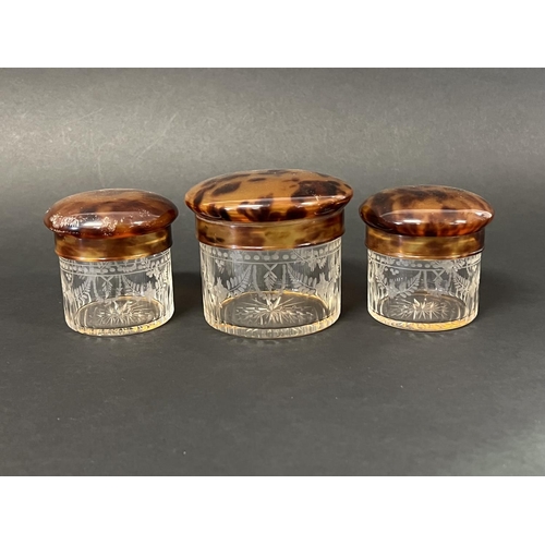 1018 - Set of three clear etched decorated glass toilet jars with faux tortoise shell lids, approx 8.5cm H ... 